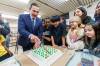 Premier Wab Kinew cut a cake at the announcement. (Mike Deal / Free Press)